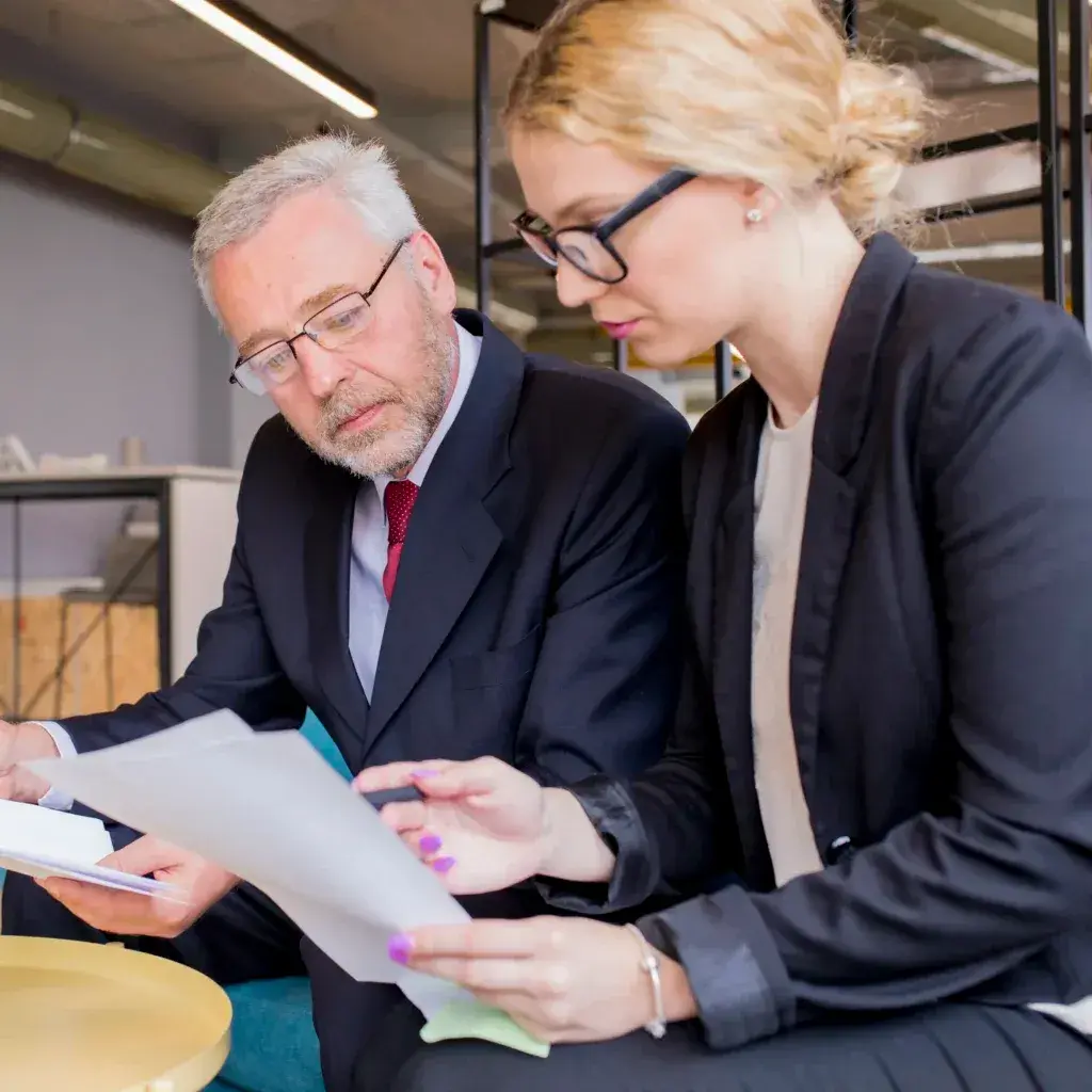 Dos consultores revisando documentos durante una reunión