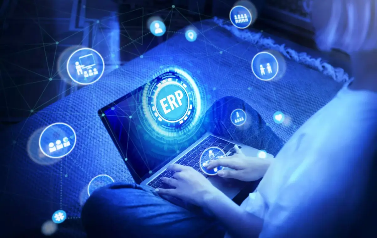 Profesional trabajando en un portátil con iconos de un sistema ERP conectado